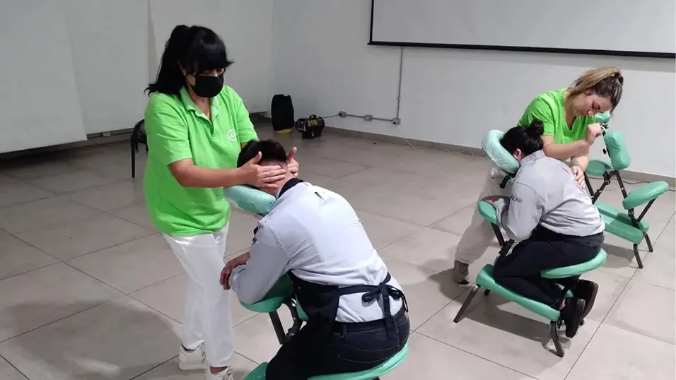 Masaje express en silla en sala de reuniones